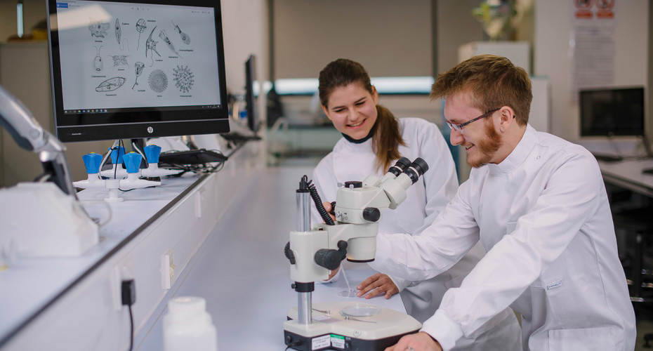 Students looking into microscope