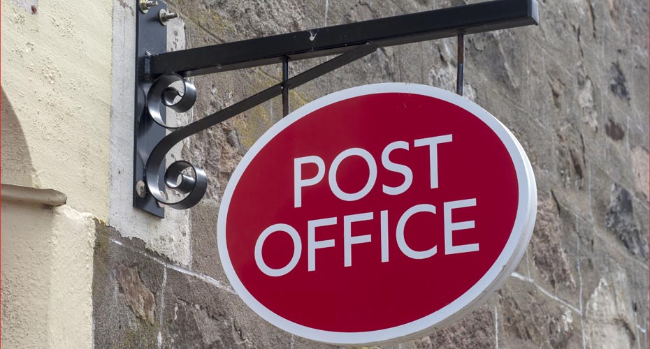 Sign on wall outside a Post Office