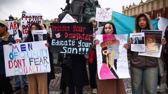 Demonstrators hold protest signs