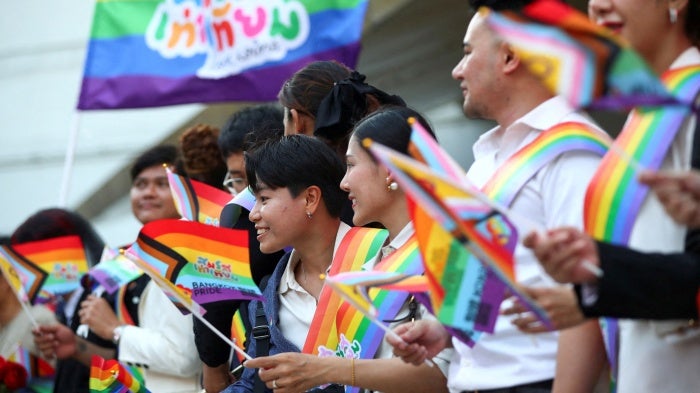 People in Bangkok hold rainbow flags celebrating the passage of Thailand’s Marriage Equality Act, June 18, 2024.