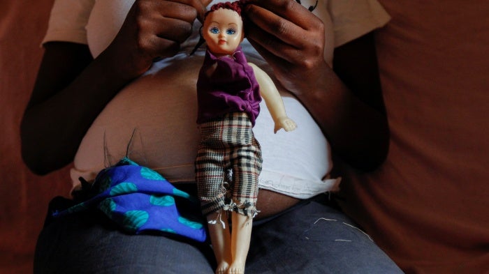 A secondary school student who is pregnant holds a doll inside her home in the Kibera slums of Nairobi, Kenya on September 30, 2020. (