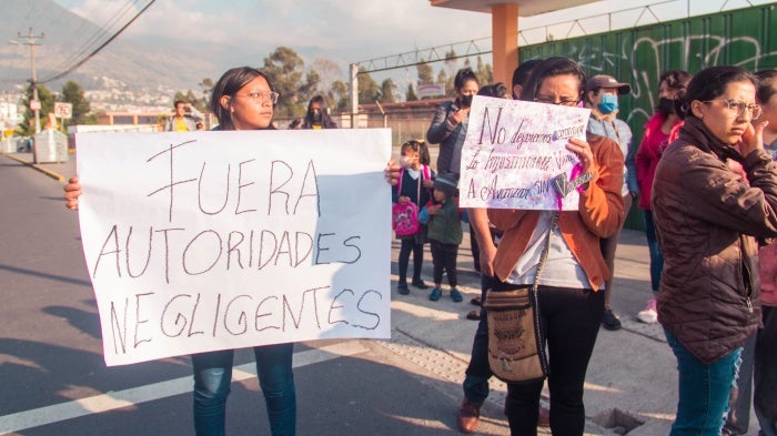 Women hold banners in Spanish at a protest