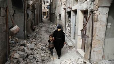 Woman and child in rubble in Idlib