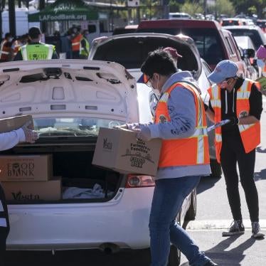 Volunteers load food into the trunk of vehicles during a ''Let's Feed LA County'' drive-thru food distribution by the Los Angeles Regional Food Bank and the office of Supervisor Hilda Solis on February 23, 2021, in La Puente, California.