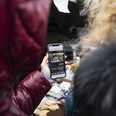 Two women from Kharkiv, Ukraine, watch news on a mobile phone, just after having crossed the border into Moldova, on March 10, 2022.