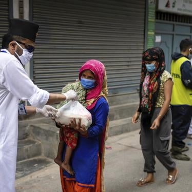 A woman and her child receive relief goods distributed by a community service center in Kathmandu, Nepal on June 4, 2021. 