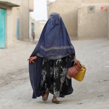 An Afghan woman carries empty containers to fetch water in Nahr-e-Shahi district in Balkh province, Afghanistan, August 6, 2023. 