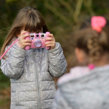 Two young girls are playing with their cameras in a garden, Osterode, Germany, January 8, 2016. 