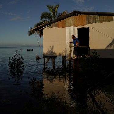 Local resident of Veivatuloa Village in Fiji looks out at seawater flooding around his home at high tide in July 16, 2022.