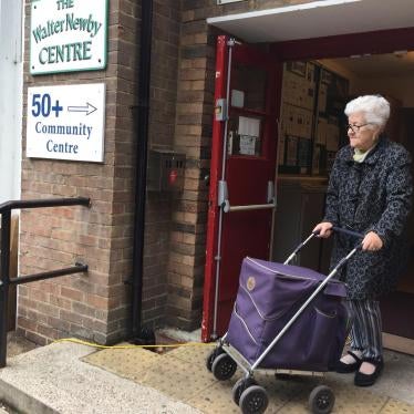 Older woman leaving a community center with programs for older people in East London. 