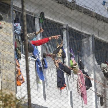 Inmates point from inside of La Modelo prison in Bogota, Colombia, Sunday, March 22, 2020.