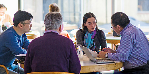 A group of scholars collaborating around a table.