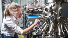 NREL scientist uses a Compound Semiconductor Molecular Beam Epitaxy System to grow semiconductor samples in the Semiconductor Growth lab at the Solar Energy Research Facility at NREL.