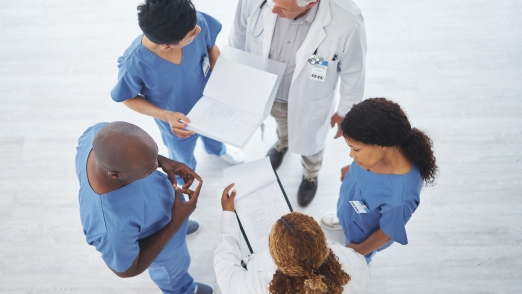 Finding solutions to complex cases from several perspectives. High angle shot of a group of medical practitioners having a discussion together in a hospital.