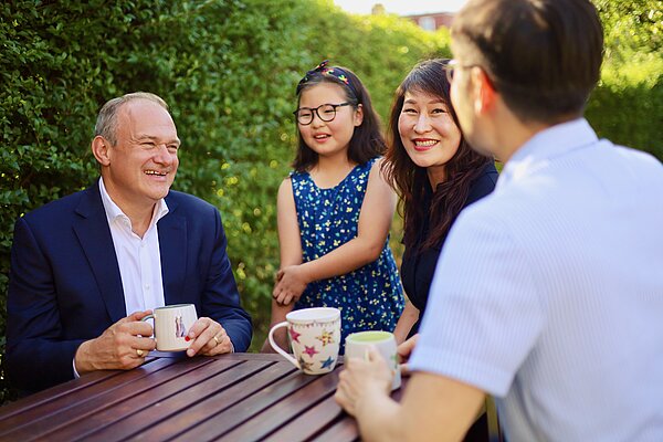 Ed Davey listens to a family