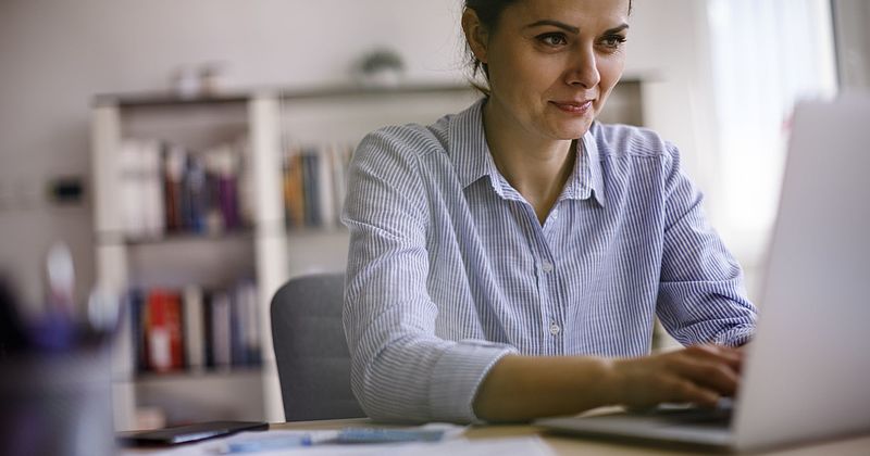 Junge Frau sitzt vor einem Laptop