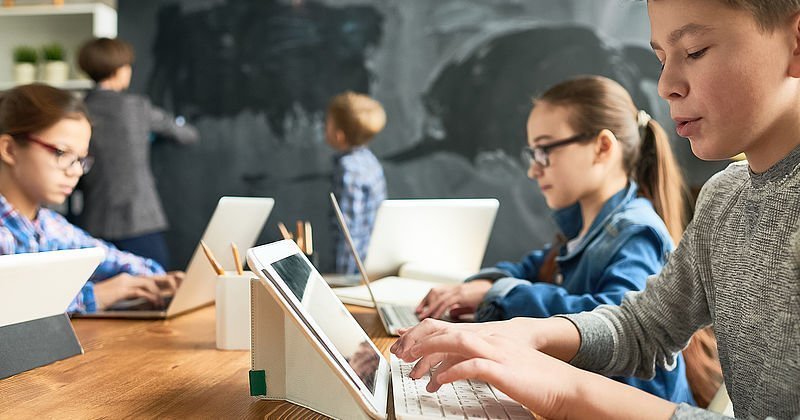 Schüler mit Tablets und Laptops