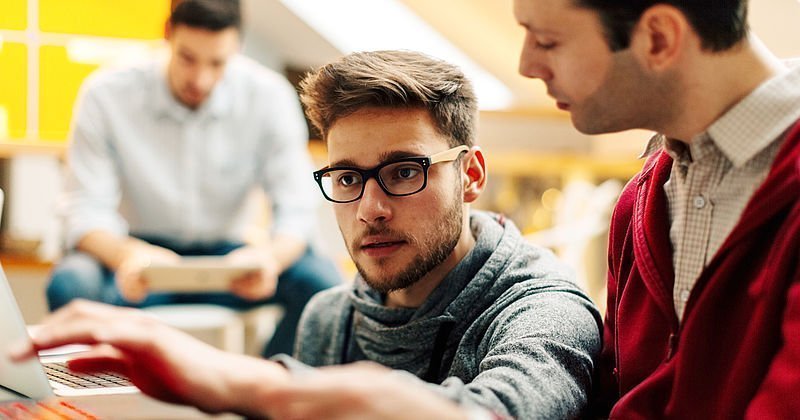 Zwei junge Männer beim Arbeiten am PC