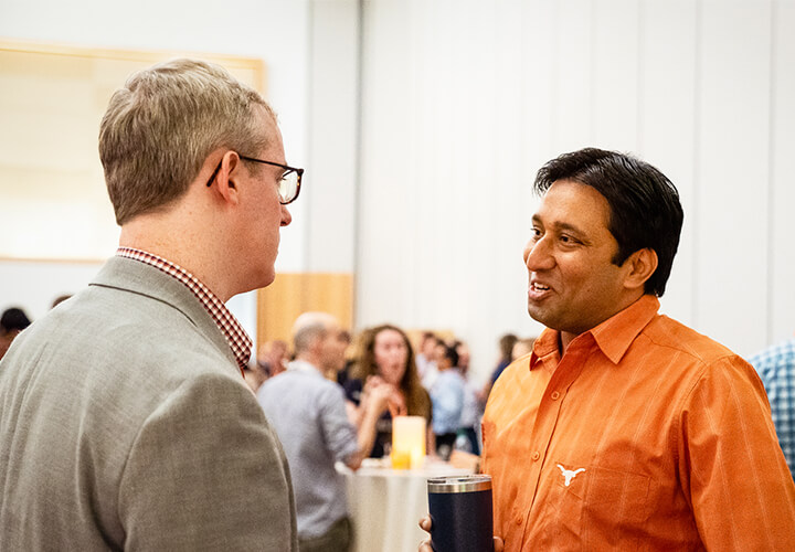 Two conference attendees stand and network