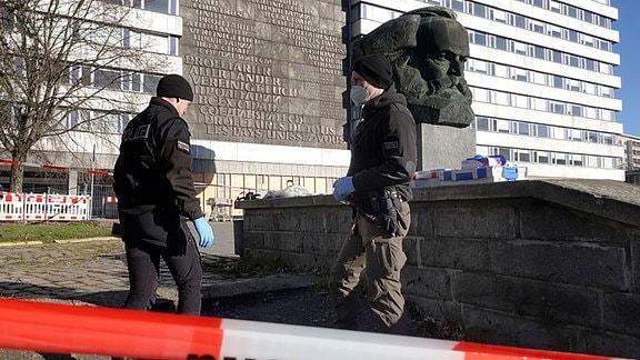 Kriminalbeamte bei der Spurensuche am abgesperrten Tatort am Karl-Marx-Kopf in Chemnitz