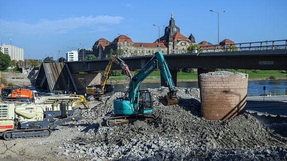 Bagger beseitigen auf der Altstädter Elbseite Trümmerteile des eingestürzten Brückenzuges der Carolabrücke.