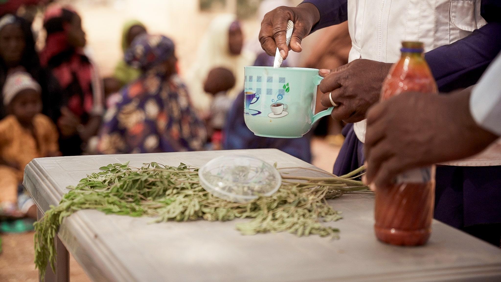 Acute Malnutrition in Nigeria: Maryam Muhammad, MSF health promotion supervisor in Kebbi, holds a cup during a Tom Brown recipe demonstration in Maishaika village, Kebbi State, North West Nigeria. Around a hundred women participated in this demonstrati