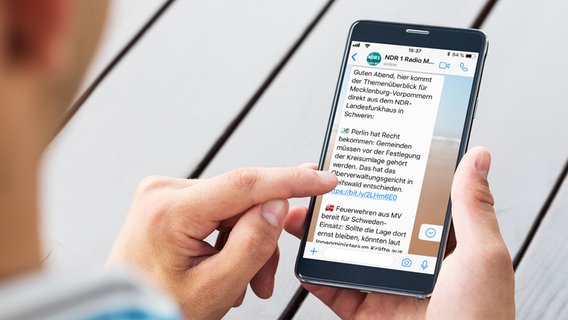 Ein Mann hält seinen Finger auf das Handy und liest eine Whatsapp-Nachricht. © Fotolia / preto perola 