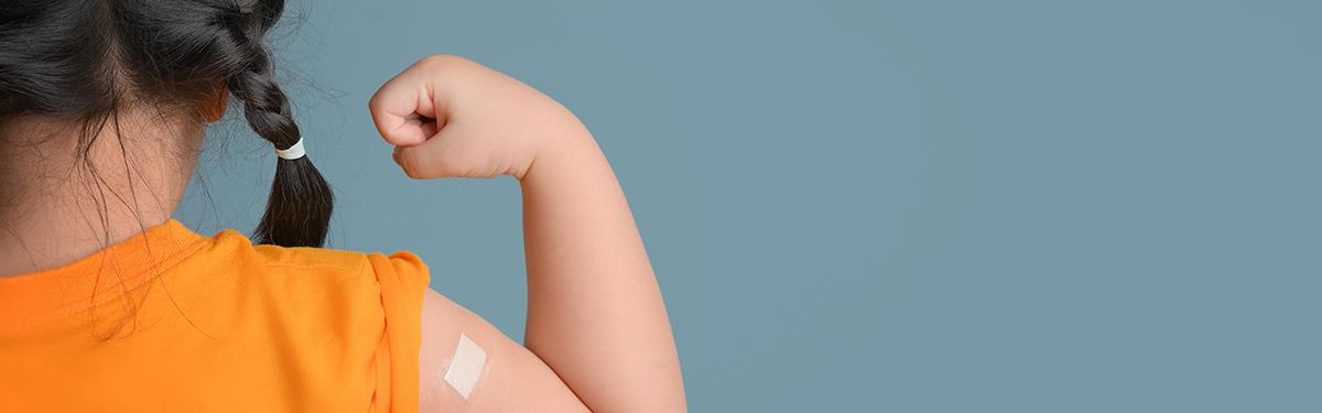 Generic photo of a child with a plaster on upper right arm after receiving an injection