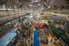 View from near ceiling shows NCNR guide hall filled with big pieces of scientific equipment, including several long cylindrical "guides" running toward the far end of the room. 