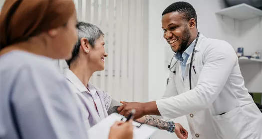 Smiling HCP taking senior patient's blood pressure