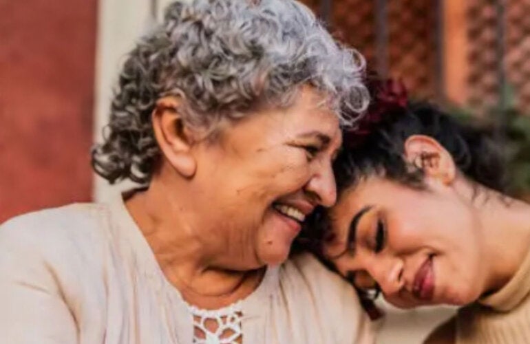 Older adult embraced by family member