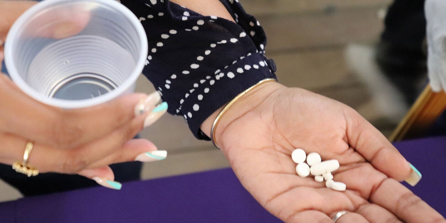 Una mujer tiene las pastillas en su mano para tratar la filariasis linfática