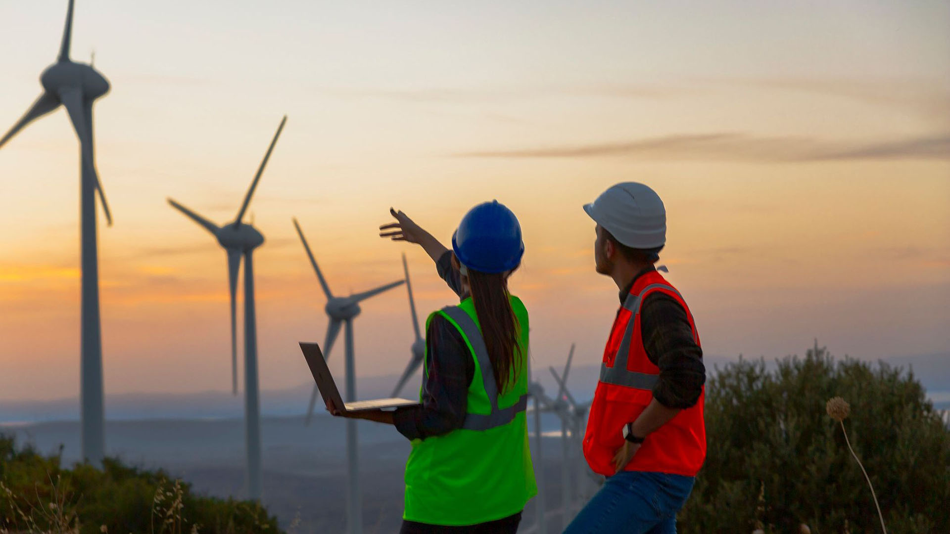 workers pointing at windmills