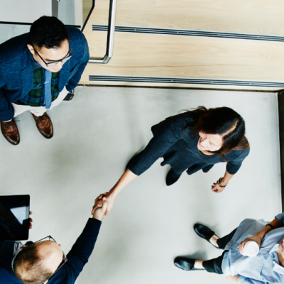 Group of professionals working in an office. Two are shaking hands