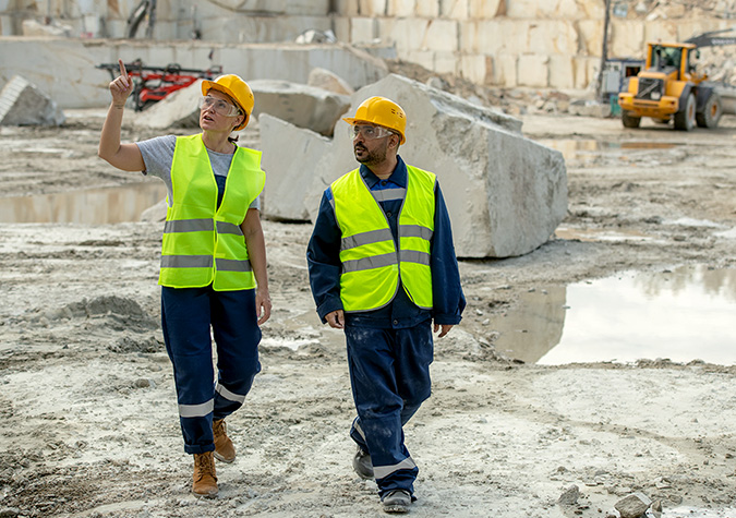 Bergmaterialarbetare som samtalar om arbetet hos sin arbetsgivare.