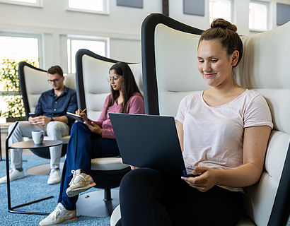 Drei Studierende im Opp:Lab am Laptop im Ohrensessel