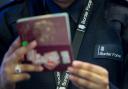 Border Force officer checking passports of arrival passengers