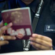 Border Force officer checking passports of arrival passengers