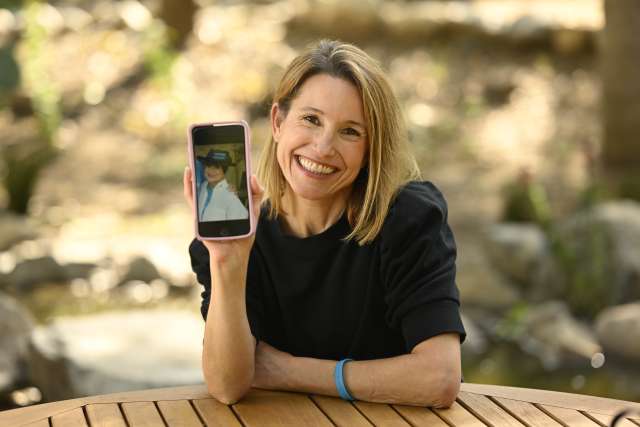 Kelli Sargent holds up her cell phone showing a photo of her mother.