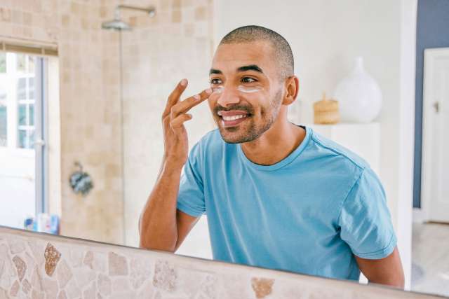 Man applying lotion to his face. 