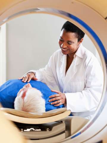 Radiologist preparing patient for PET-CT scanner.