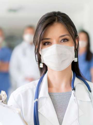 Female doctor with a group of doctors in background