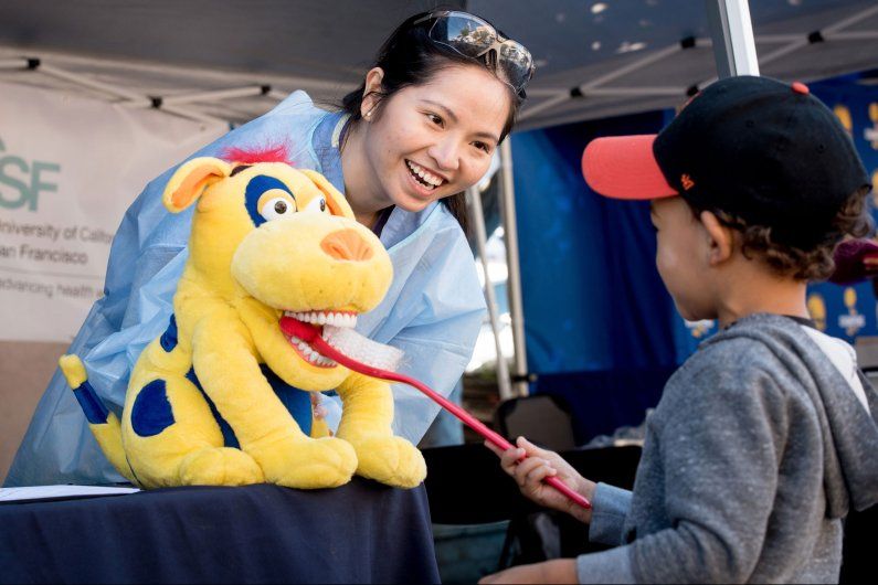 Dental student and a community member interaction at a fair. 