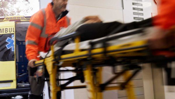 Paramedics wheel a patient on a gurney into a hosptial's emergency department.