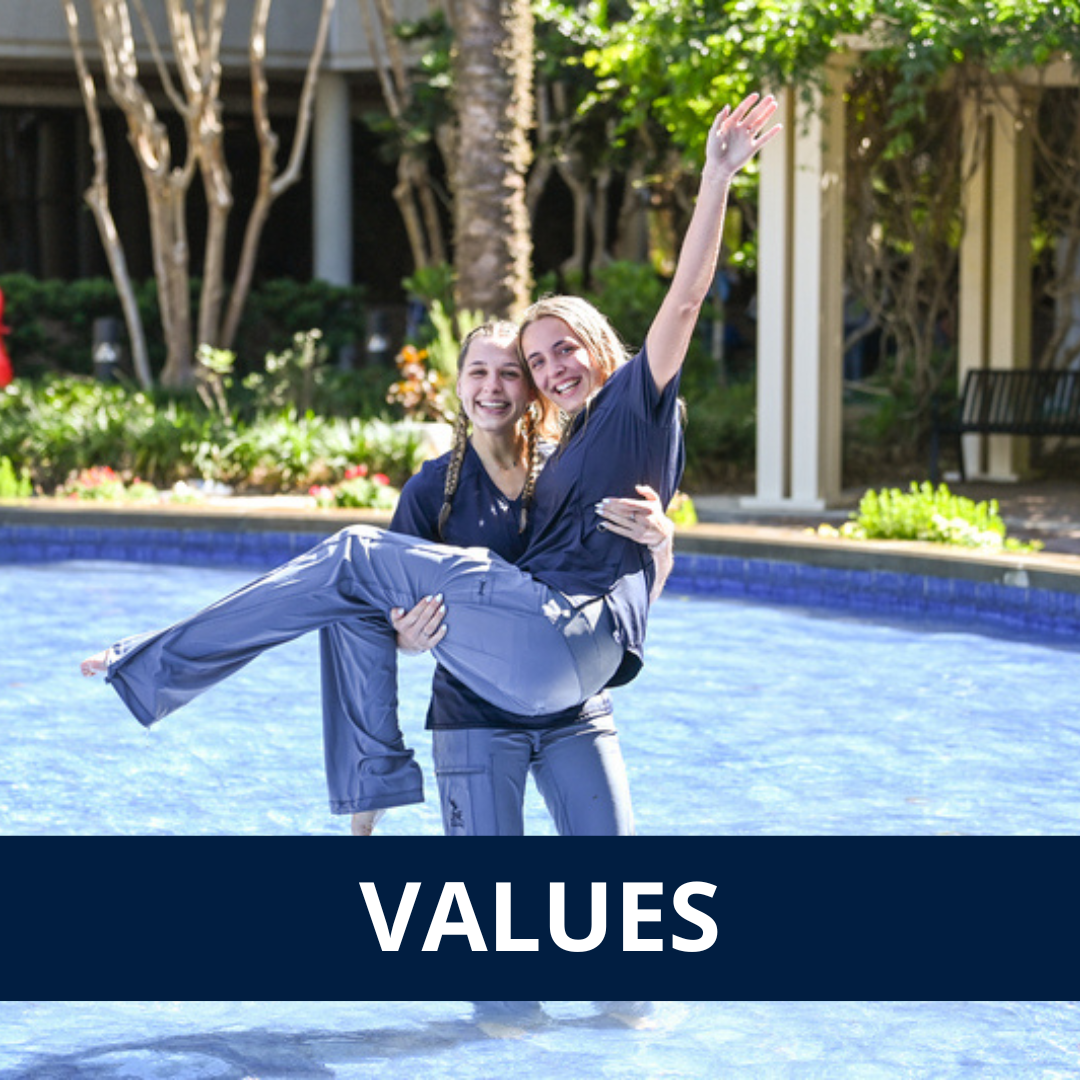 text: values. Image: two nursing students in the BCH Fountain celebrating graduation. One of the students is holding the other