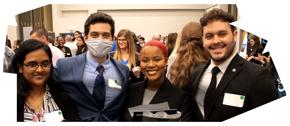 Group of students dressed for a career fair behind the Handshake logo