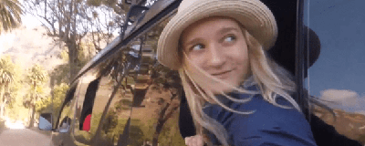 a woman with her head out a van window