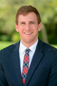 Headshot of caleb Garrett, where he is smiling and the picture is long.