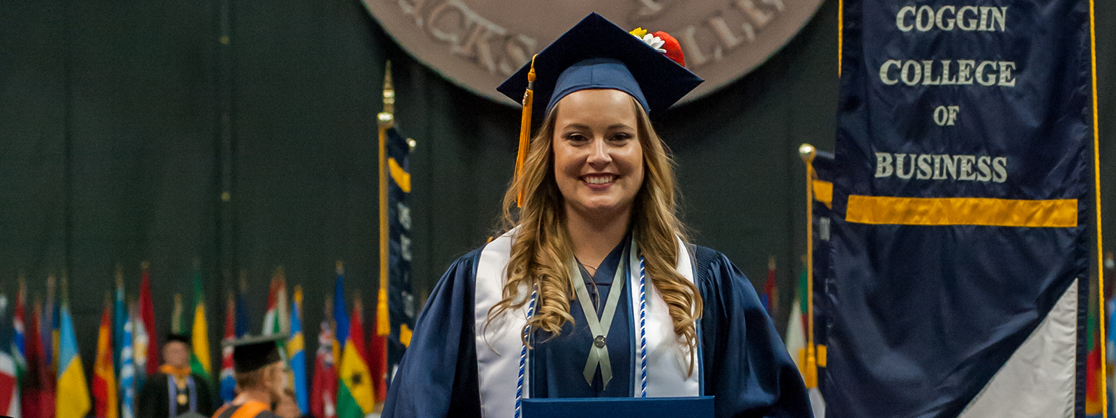 coggin grad holding her degree during the ceremony