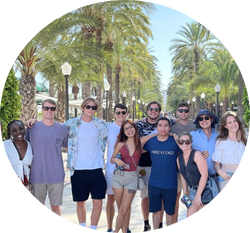 group of UNF students smiling on a palm-tree lined pedestrian street in Alicante